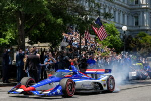IndyCar Series driver David Malukas drives a race car down West Executive Drive during an event with President Donald Trump