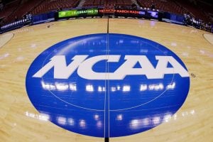 This photo taken with a fisheye lens shows the NCAA logo displayed at mid-court in Philadelphia, March 21, 2013. (AP
