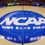 This photo taken with a fisheye lens shows the NCAA logo displayed at mid-court in Philadelphia, March 21, 2013. (AP