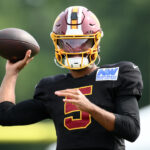 Washington Commanders quarterback Jayden Daniels works out before a joint practice with the Miami Dolphins at NFL football