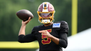 Washington Commanders quarterback Jayden Daniels works out before a joint practice with the Miami Dolphins at NFL football