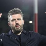 Manchester United head coach Michael Carrick holds his hands up to apologise to the away fans in Como