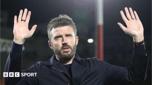 Manchester United head coach Michael Carrick holds his hands up to apologise to the away fans in Como
