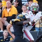 Ohio State Buckeyes wide receiver Jeremiah Smith (4) is hit by Iowa Hawkeyes wide receiver Evan James (8) as he attempts a
