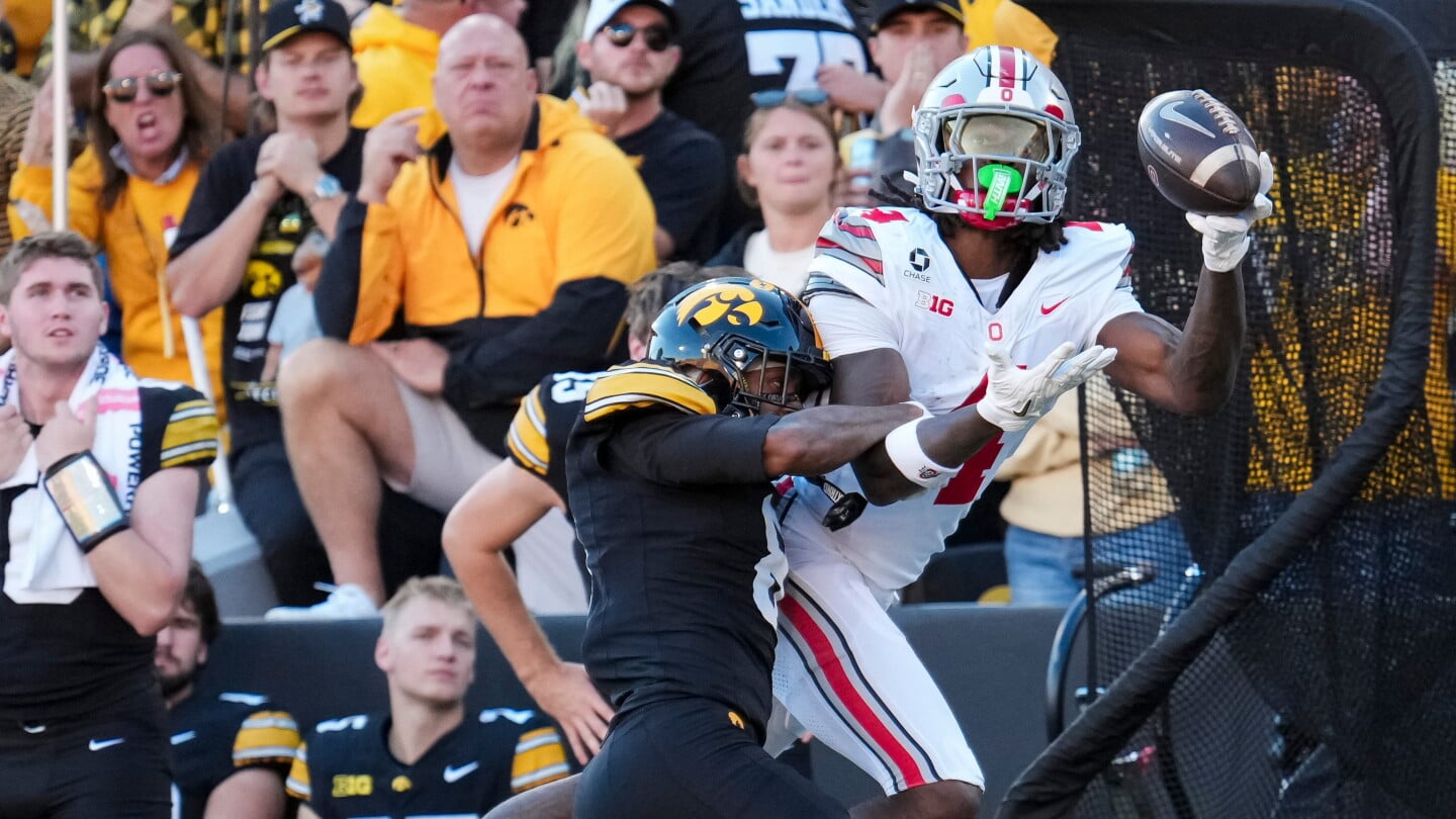 Ohio State Buckeyes wide receiver Jeremiah Smith (4) is hit by Iowa Hawkeyes wide receiver Evan James (8) as he attempts a